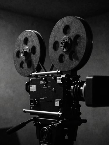 Grainy black and white 35mm film close-up of a movie camera rig in a dark, concrete room, harsh chiaroscuro lighting, raw texture.