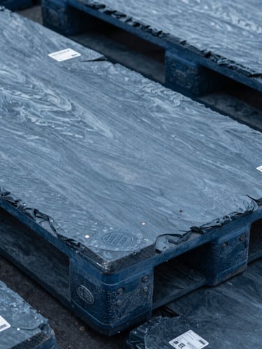 Close-up of secured industrial pallets with customs clearance seals, sharp focus, cool slate tones.