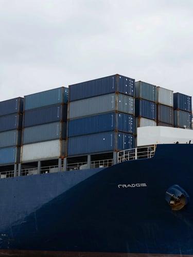 Sharp overhead angle of a massive container ship grid, deep blue maritime tones, high-contrast overcast daylight.