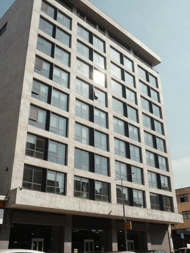 Wide shot of a Lagos commercial property facade at midday, clean concrete and glass exterior, street-level perspective, natural daylight, no people, architectural documentation style