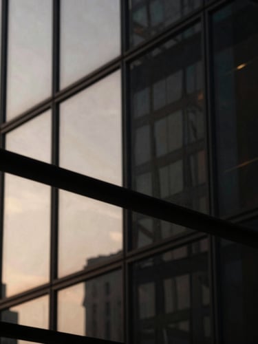 Macro photograph of architectural glass reflecting sharp, dramatic side-lighting, deep obsidian shadows, warm champagne highlights, ultra-premium editorial aesthetic.