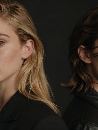Close-up cinematic portrait of a stylish male and female model showing professional hair styling, moody low-key lighting, warm champagne gold accents, shallow depth of field, 35mm