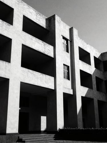Stark monochrome photograph of modern Indian legal architecture, high-contrast directional light, deep shadows, low-angle shot, 35mm