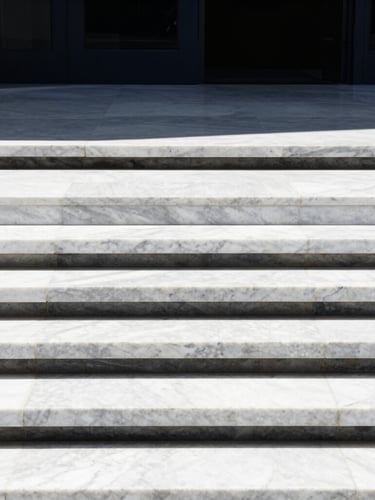 A minimalist architectural detail of premium white marble steps meeting a dark steel frame, crisp high-contrast sunlight, clean lines, editorial style.