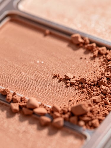 Macro shot of warm terracotta makeup powder texture, soft golden hour side-lighting, shallow depth of field