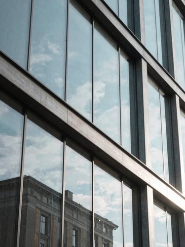 Macro shot of modern architectural glass and steel in Helsinki, cool natural Nordic daylight, crisp shadows, 35mm