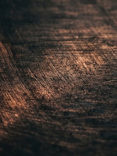 Extreme macro close-up of brushed copper surface, dark moody editorial photography, dramatic low-key side lighting, deep charcoal and copper tones, 35mm