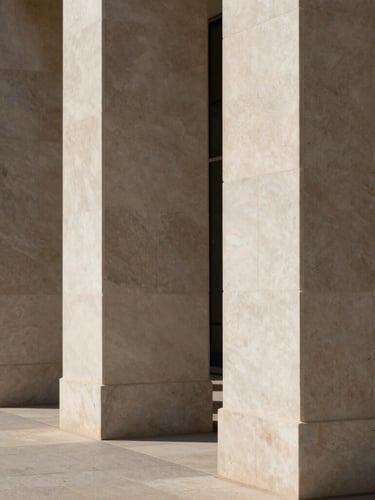 A sharp architectural detail of modern limestone columns aligned under soft, directional natural daylight, minimal shadows, editorial style