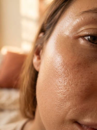 Close-up of real skin texture with natural dewiness under warm golden-hour window light, soft morning shadows, cream and terracotta tones