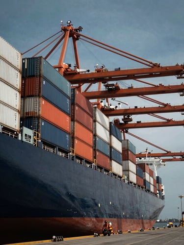 Massive container ship docked at the Lázaro Cárdenas port under dramatic industrial lighting, wide shot