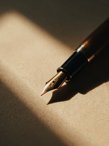 Extreme close-up of a vintage fountain pen resting on heavy cotton paper, warm golden-hour window light, dramatic chiaroscuro, 35mm film grain