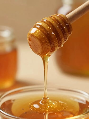 Close-up of raw honey dripping slowly from a wooden dipper, warm side-lighting, soft focus, rich amber tones, editorial style.