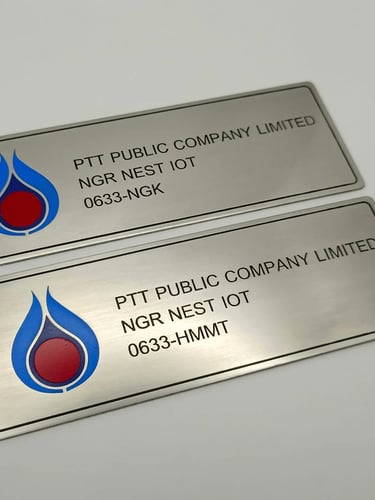 Custom engraved stainless steel metal nameplates with the PTT Public Company Limited logo and text.