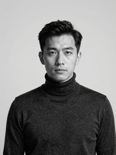A high-contrast black and white studio portrait of a male designer in a dark turtleneck, direct clean clinical lighting, sharp focus, orthographic projection, negative space on the right.