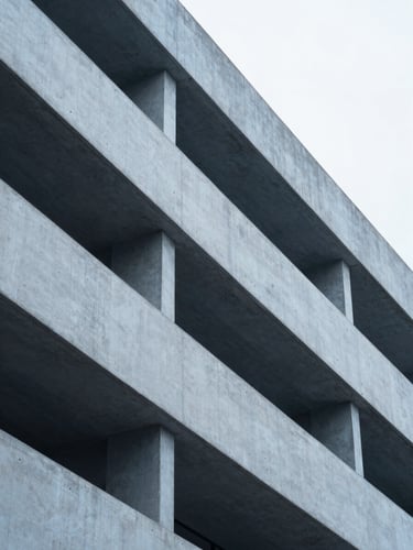 Macro architectural photograph of clean concrete lines and steel beams of a modern financial institution, soft overcast daylight, cool desaturated blue tones.