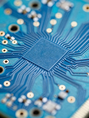 Extreme macro close-up of a high-density multilayer printed circuit board, showing gold-plated microvias and trace routing under cool blue light, sharp depth of field