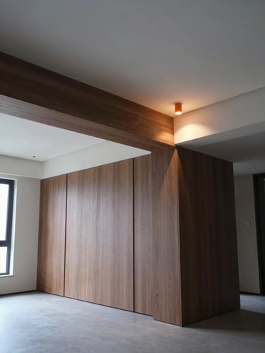Wide-angle interior of a completed luxury residential living space — structural beam junction with ceiling plaster meeting a wall of bespoke joinery, a single deep-orange accent light mounted in the ceiling detail casting a precise glow on the timber edge, cool ambient daylight from the left, no staging furniture, finish quality the subject