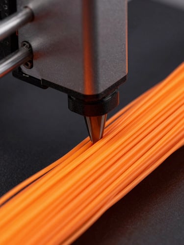 Extreme close-up of a 3D printer nozzle extruding vibrant neon orange filament, high-contrast studio lighting, dark matte background