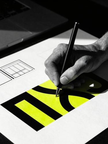 High-contrast black and white portrait of a graphic designer working with packaging blueprints, harsh shadows, professional studio setting