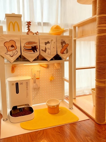 Warm cat care corner with litter box, feeding mat, storage shelf and small pet essentials arranged i