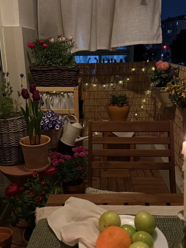 Cozy balcony with warm ambient lighting and natural wooden textures, inspired by warm European outdoor living