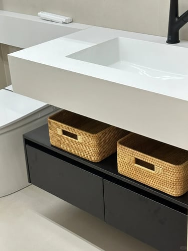 Woven storage baskets placed under a bathroom counter for organizing small pet items and home essent