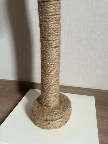 Close-up of a sisal-wrapped cat scratching post base, showing natural rope texture and sturdy constr