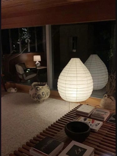 Warm interior with soft paper lamps, low table and natural textures inspired by Isamu Noguchi light