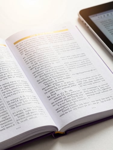 Crisp close-up of open theological study manuals and a digital tablet displaying Greek lexicons, bright high-key studio lighting, subtle gold accents on the pages.