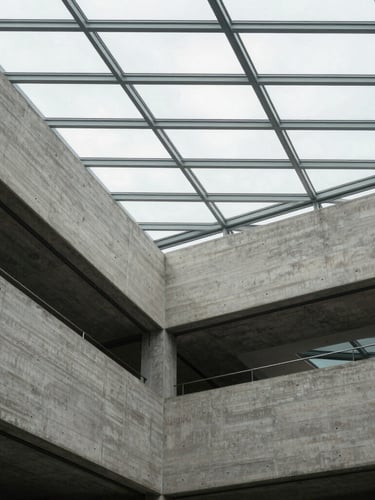 A clean, minimalist architectural detail of a concrete and glass atrium in Brussels, diffused overcast lighting, strong geometric grid lines.