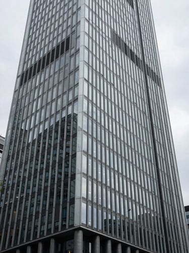 Abstract geometric architectural lines of a modern financial center facade in Frankfurt, overcast daylight, sharp structural shadows.