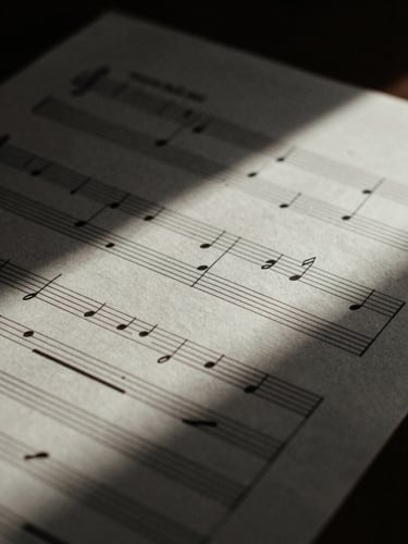 Chiaroscuro macro shot of handwritten musical manuscript paper with ink notations, soft natural side lighting, deep shadows, 35mm film grain