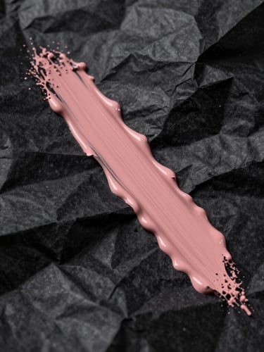 Extreme close-up of crumpled black paper with a slash of dusty rose paint, harsh flash lighting, high contrast.