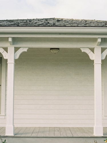 Straight-on architectural elevation of custom hand-carved timber molding inside a restored Guilford home, soft natural coastal daylight, medium format film texture