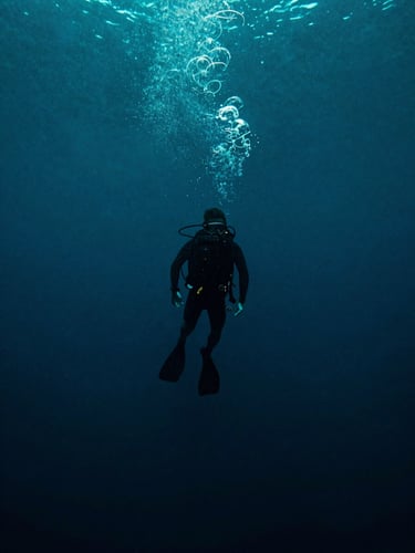 Portrait-format film poster composition, underwater deep-sea environment rendered in dark teal and midnight blue, a diver's silhouette descending into abyss, bioluminescent particles drifting upward, eerie stillness