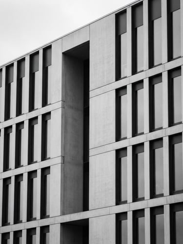 Minimalist architectural detail of a modern courthouse facade, soft overcast daylight, desaturated black and white, elegant corporate aesthetic, 35mm
