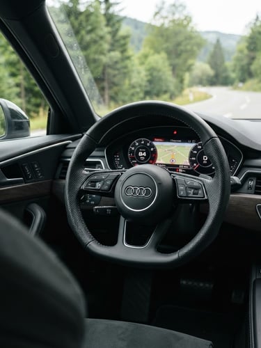 Clean eye-level shot of a detailed vehicle steering wheel and dashboard in natural daylight, focus on the wheel and instrument cluster, slightly off-center to the right, realistic outdoor setting, crisp details, 35mm lens