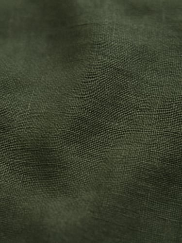 Macro detail shot of heavy forest green linen fabric texture, soft overcast daylight, 35mm film grain