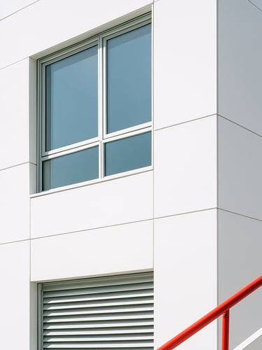 Bright minimalist photography, clean architectural detail of a modern white office building facade, sharp geometric lines, soft natural daylight, 35mm