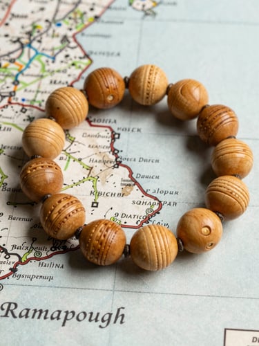 A close-up flat-lay of hand-carved wampum beads resting on a weathered historical map of Ramapough territory, soft natural side-light.