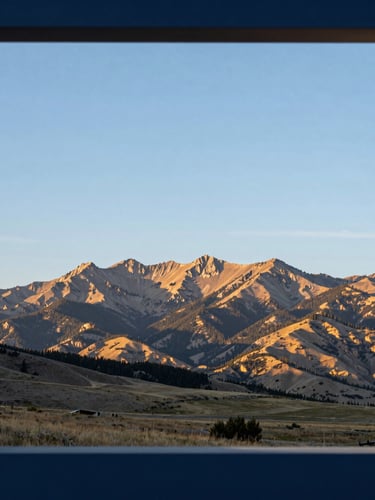 Wide panoramic Idaho landscape at sunrise, showcasing the rugged Intermountain West region, with a focus on clear skies and natural light. Architectural framing with subtle blue and gold undertones.