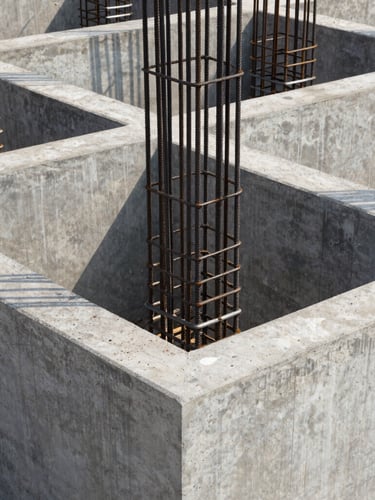 Crisp architectural photography of a modern residential concrete foundation under bright daylight, showing heavy steel reinforcement bars and precise formwork in Bengaluru.