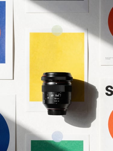 Crisp high-contrast studio setup with direct afternoon sunlight casting sharp shadows on bold graphic posters, clean white background, 35mm lens.