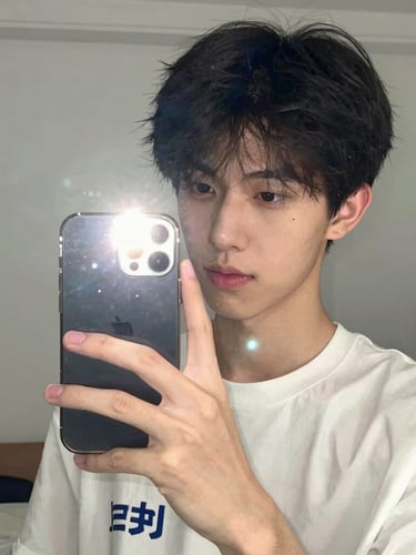 Smartphone selfie of a young adult, casual indoor bedroom setting, soft mirror reflection with phone flash, authentic social media style, portrait aspect