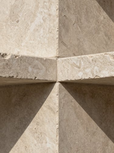 Abstract close-up of textured natural stone and soft shadows, evoking a sense of calm, structural safety, and high-end architectural design