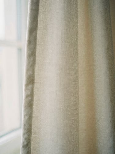 Close-up of beige linen fabric texture, soft diffused natural daylight, gentle shadows, 35mm film fashion photography