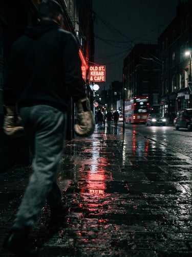 Gritty, high-contrast night shot of a dark, wet London street in Old Street, neon red light reflecting on the pavement, with a subtle, blurred figure of a boxer in the foreground, low angle, dramatic chiaroscuro, 35mm film grain.