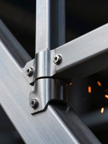 Macro detailed shot of high-end brushed steel joint on an architectural structure, dramatic orange sparks in the background, sharp industrial lighting, 35mm