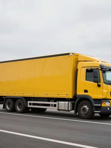 Dynamic side-profile shot of a clean yellow logistics truck driving smoothly on a highway, bright overcast sky.