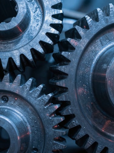 Macro close-up of heavy-duty industrial spur gears, sharp teeth interlocking, cool blue industrial lighting with subtle red ambient reflections, high-contrast steel texture.